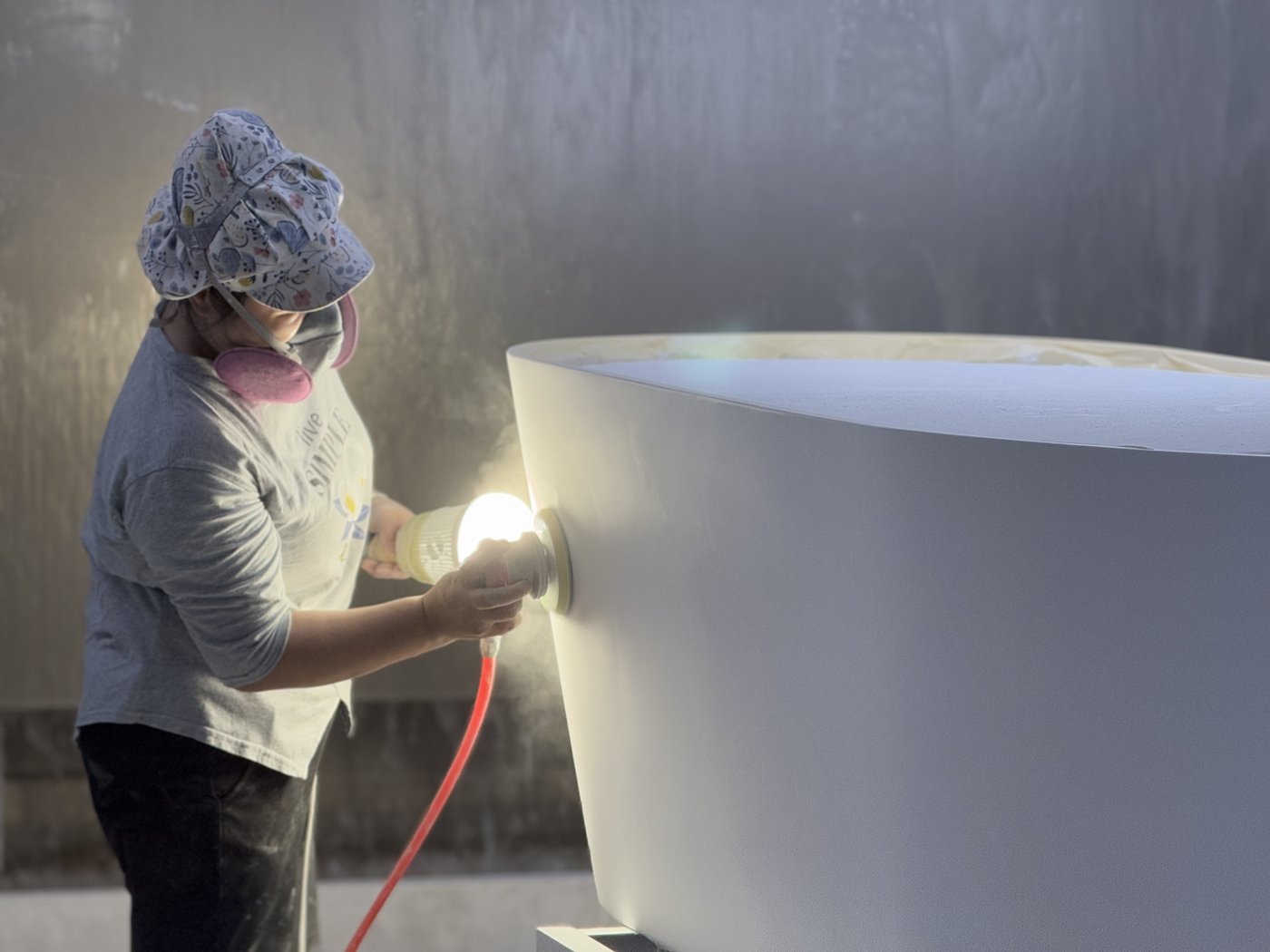 Worker inspecting the surface of a bathtub