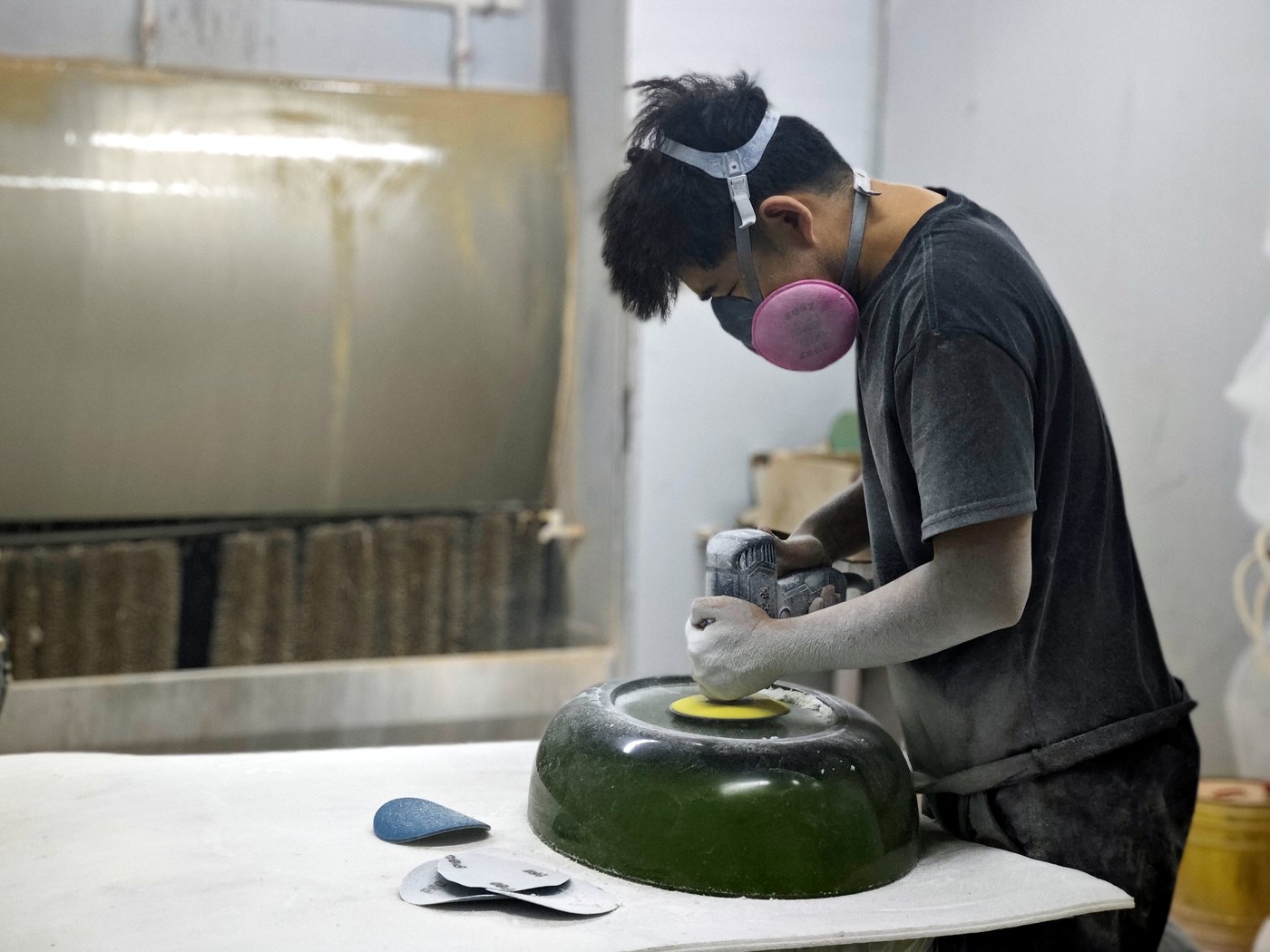 Worker hand polishing a solid surface bathtub